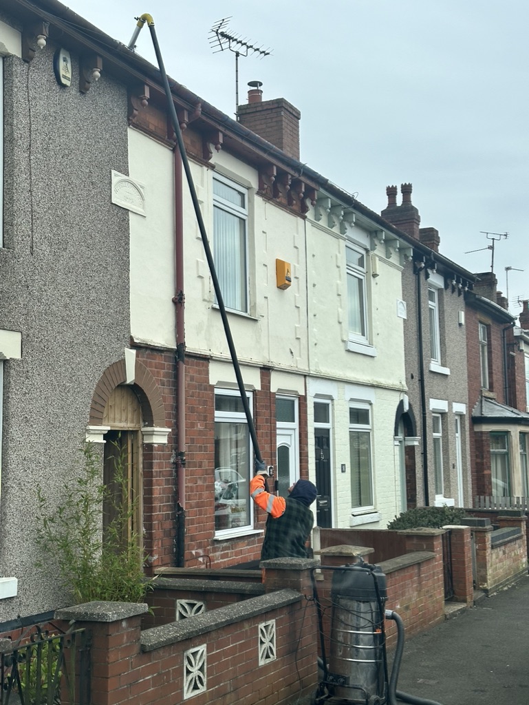 Cleaning gutters with long reach guttervac